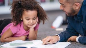 10167729-student-reading-with-teacher-on-300x168.jpeg