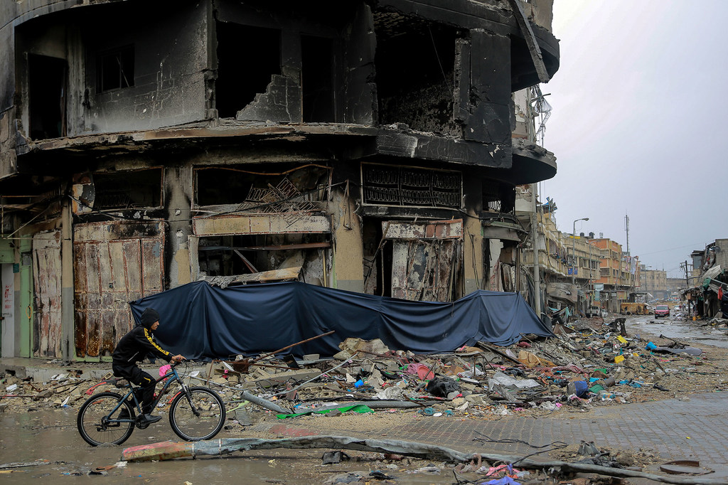 A boy cycles through the heavily bombarded Asqola neighbourhood of Gaza City. A boy cycles through the heavily bombarded Asqola neighbourhood of Gaza City.