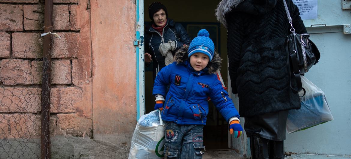 A family receives winter clothing kits for children and other supplies from UNICEF in the frontline community of Marhanets, Ukraine. (file). A family receives winter clothing kits for children and other supplies from UNICEF in the frontline community of Marhanets, Ukraine. (file).