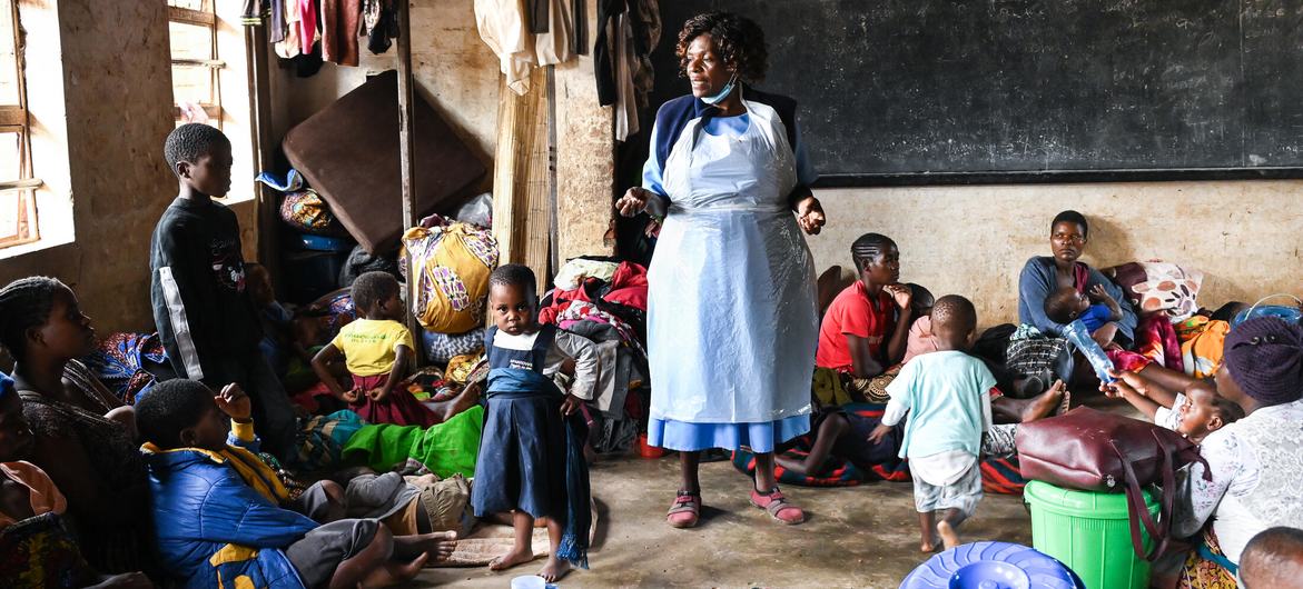 A health worker at a camp in southern Malawi, talks to displaced people about cholera prevention measures.